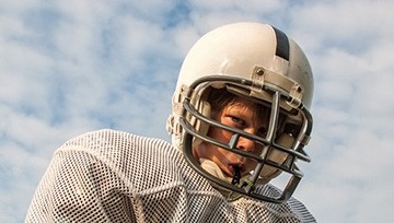 Boy playing football and wearing a mouthguard