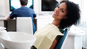 A young woman lying back in a dentist’s chair in preparation to see her dentist near Burns Park, MI