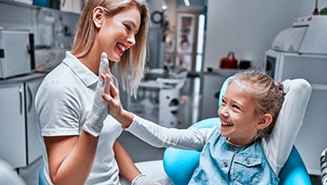 Young girl high-fiving children’s dentist in Ann Arbor