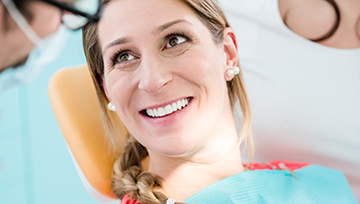 Woman in dental chair talking to dentist