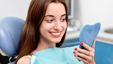 Woman looking at smile in mirror