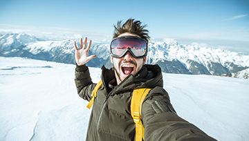 adventurous person taking a selfie while snowboarding