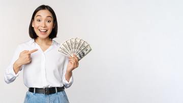 a woman holding money to pay cost of cosmetic dentistry