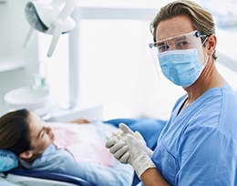 Emergency dentist wearing a mask while helping patient