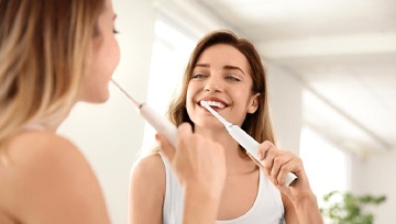 Woman brushing teeth to prevent dental emergencies in Ann Arbor