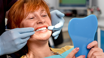 Senior woman examining smile in mirror