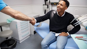 patient shaking his dentist’s hand 