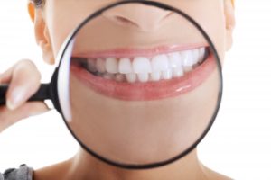 woman smiling holding magnifying glass