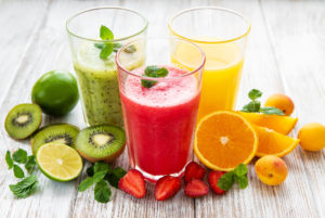 Fruit smoothies and fresh fruits on a old wooden table