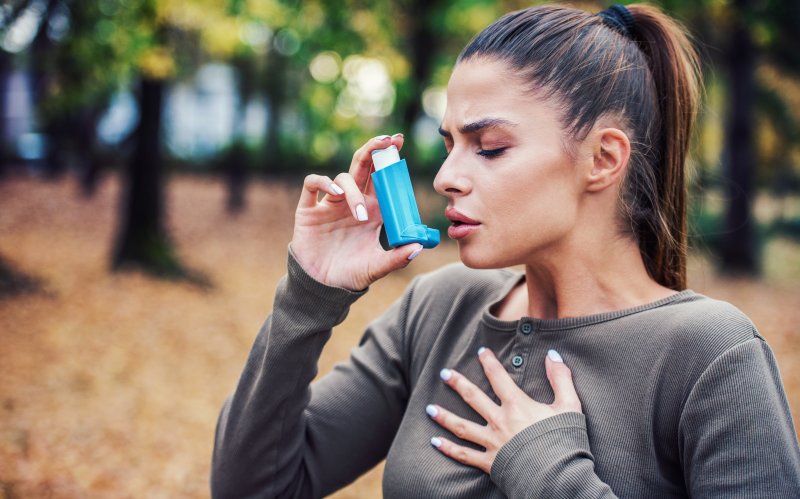 Young woman holding out her inhaler