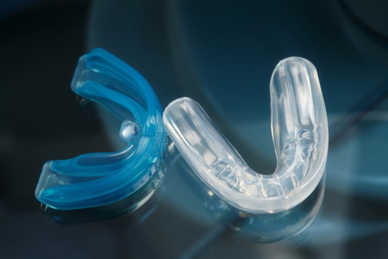 Two mouthguards, one blue and one clear, next to each other