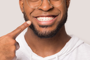 Close-up of man pointing to his smile