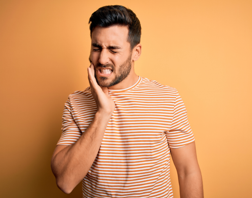 Man holding jaw in pain 